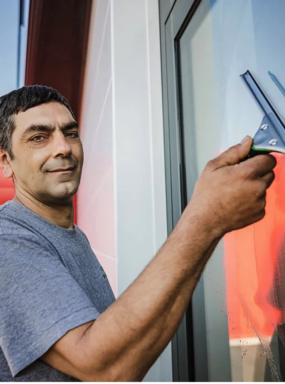 Mann putzt ein Fenster