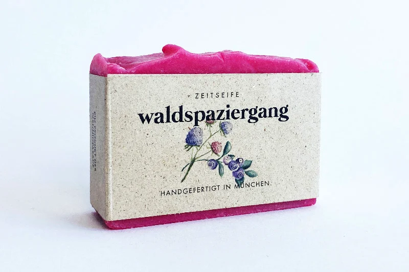 Ein pinker Seifenblock gehüllt in eine Papierverpackung mit floral bedrucktem Etikett
