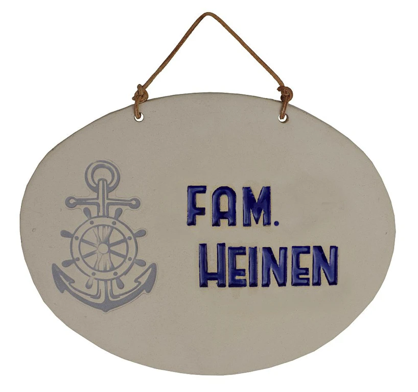 Weißes ovales Tonschild mit blauer Aufschrift "Fam. Heinen" mit Ankersymbol