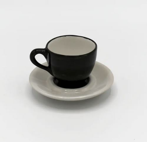 Schwarze Espresso Tasse auf weißem Teller