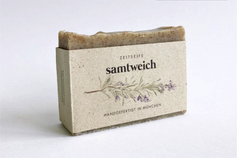 Ein brauner Seifenblock gehüllt in eine Papierverpackung mit floral bedrucktem Etikett