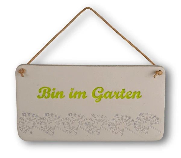 Weißes ovales Tonschild mit grüner Aufschrift "Bin im Garten" mit Pusteblumenverzierung