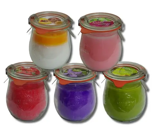 Gestapelte Duftkerzen im Glas in verschiedenen Farben