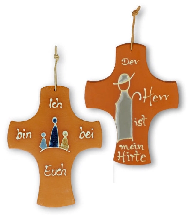 Ein Tonkreuz mit bunten Details und Aufschrift "Ich bin bei Euch" und "Der Herr ist mein Hirte"als Anhänger