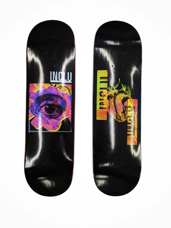 zwei schwarze Skateboard Decks mit einem lila Augenausschnitt und gelb orangenem Herz 